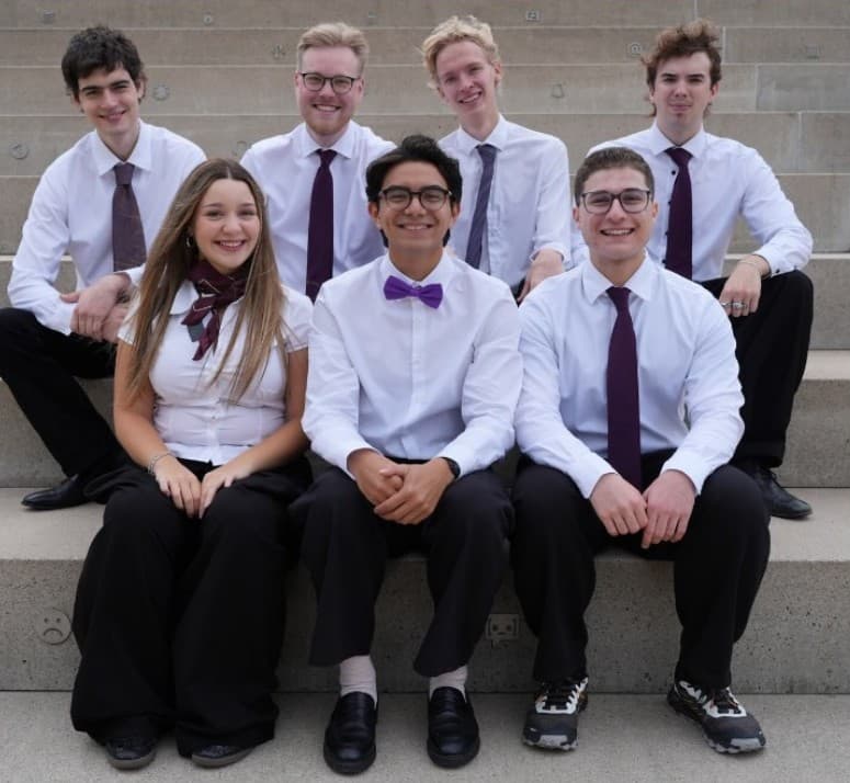The seven members of EMA's 9th board sitting together on outdoor steps