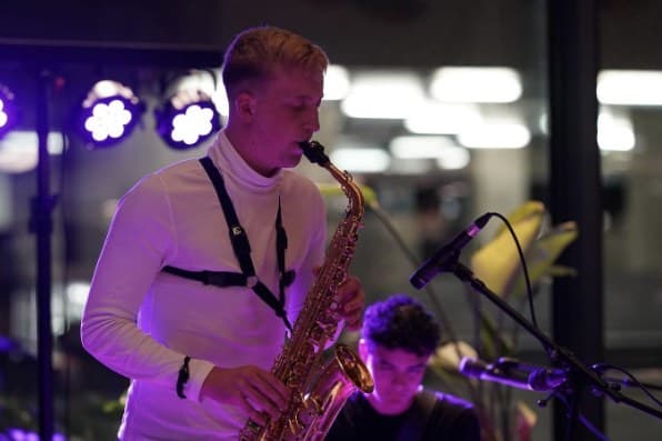Saxophonist playing under bright stage lights